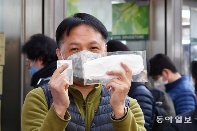 9일 오전 서울 종로 한 대형약국 앞에서 한 시민이 마스크 구매한 것을 취재진에게 보여주고 있다. 박영대기자 sannae@donga.com