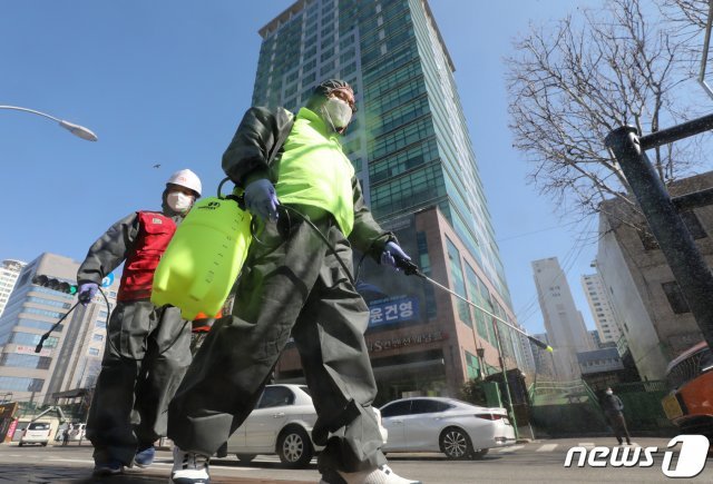 구로구 신도림동 콜센터에 발생한 신종 코로나바이러스 감염증(코로나19) 확진자가 90명으로 늘어난 11일 콜센터가 위치한 서울 코리아빌딩 앞 버스정류장에서 구로구시설관리공단 관계자들이 방역 작업을 하고 있다. 2020.3.11/뉴스1 © News1