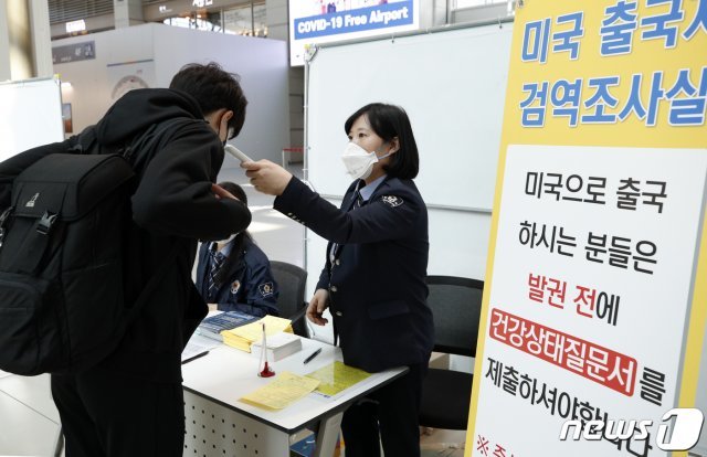 미국행 출국 승객을 대상으로 출국 전 신종 코로나 바이러스 감염증(코로나19) 검역이 강화된 11일 인천국제공항에서 미국행 승객이 건강상태질문서 제출 후 발열체크를 하고 있다. © News1