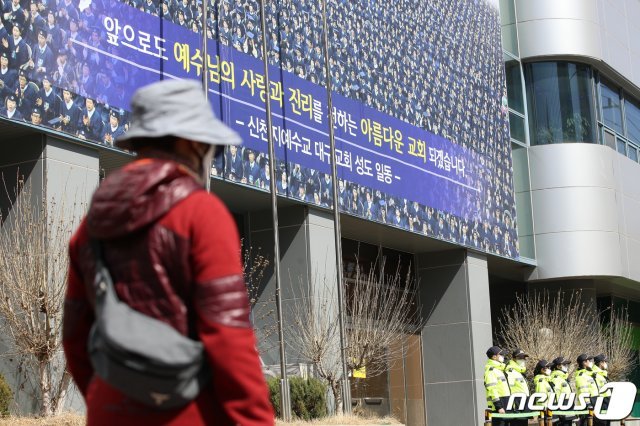 대구시가 신종 코로나바이러스 감염증(코로나19) 확산 관련 신천지 대구교회에 대한 역학조사에 들어간 12일 오후 대구 남구 대명동 신천지 대구교회 건물 앞에서 경찰 병력이 주변을 통제하고 있다. 이날 대구지역 신천지 신도 5600여명의 자가격리가 해제된 가운데 역학조사가 진행되는 신천지 대구교회 주변에는 신분을 밝히지 않은 여러 명이 휴대전화를 이용해 사진을 찍거나 건물 주변을 서성이기도 했다. 경찰은 이날 신천지 대구교회 주변에 기동대 1개 중대와 형사 등 경찰 병력을 배치해 만일의 사태에 대비했다. 2020.3.12/뉴스1 © News1