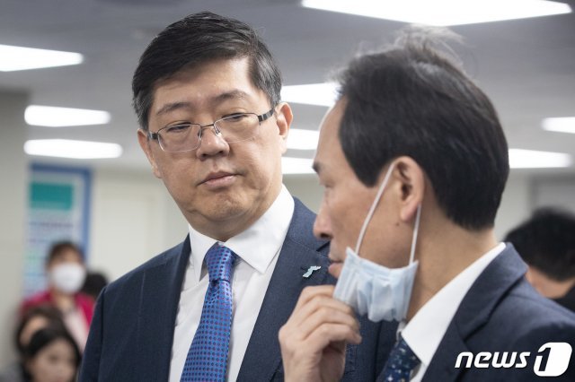 김홍걸 더불어민주당 비례대표 후보가 14일 서울 여의도 민주당사에서 열린 제2차 중앙위원회에서 우상호 의원과 대화하고 있다. 민주당은 이날 4·15 총선을 위한 비례대표 후보 순번을 결정한다. 이날 중앙위원회는 신종 코로나바이러스 감염증(코로나19) 확산으로 인해 당 지도부 및 비례대표 후보자 등 최소 인원만 참석, 온라인 생중계로 진행됐으며 비례대표 후보 순위투표도 비대면 온라인 투표로 진행된다. 2020.3.14/뉴스1 © News1