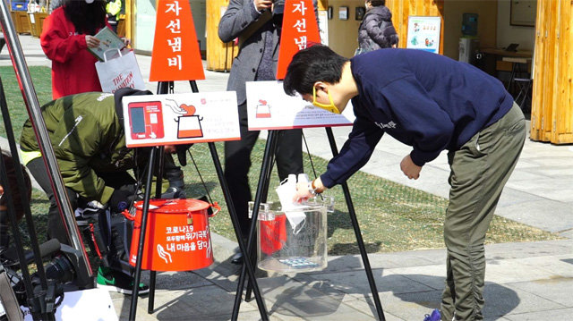 한 시민이 구세군 자선냄비에 마스크를 기부하고 있다. 구세군 한국군국 제공