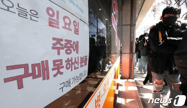 15일 오후 경기도 수원시내 한 약국 앞에서 시민들이 마스크를 구매하기 위해 길게 줄 서 있다. 2020.3.15/뉴스1 © News1