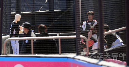 KT 투수들이 16일 수원KT위즈파크 불펜에서 타자 자리에 마네킹(왼쪽)을 세워놓고 공을 던지고 있다. 투수들이 타자 몸쪽 공을 적극적으로 던질 수 있게 하기 위한 ‘클로저’ 이대은의 아이디어다. 수원｜김종원 기자 won@donga.com