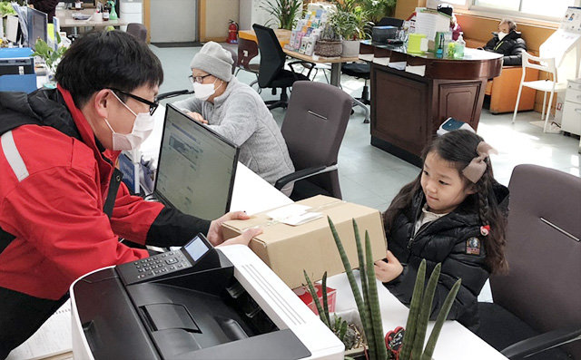 16일 대구 동구 불로·봉무동 행정복지센터에서 이채윤 양(오른쪽)이 직원에게 편지와 손소독제가 담긴 상자를 전하고 있다.