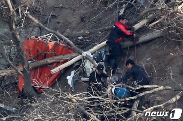 19일 오후 3시께 울산 울주군에서 산불 직화작업을 벌이던 기장과 부기장 등 2명이 탑승한 소방헬기 1대가 옛 통천마을 뒷편 회야댐에 추락한 가운데 헬기 밤비 버킷(Bambi bucket, 헬기에 줄을 매달아 쓰는 물통) 옆으로 소방대원들이 기장 1명을 구조하고 있다. 2020.3.19/뉴스1