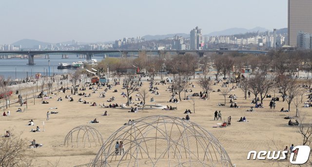 포근한 봄 날씨가 이어지고 있는 18일 오후 서울 영등포구 여의도 한강공원을 찾은 시민들이 여유로운 시간을 보내고 있다. 2020.3.18/뉴스1 © News1