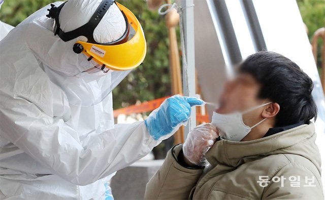 12일 오후 신종 코로나바이러스 집단 감염증 확진자가 나온 서울 구로구 보험사 콜센터 건물에서 한 입주민이 검체 검사를 받고 있다. 전영한 기자 scoopjyh@donga.com