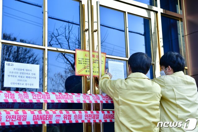 광주시와 북구청 관계자들이 27일 오후 광주 북구 오치동 신천지 베드로지성전(광주교회) 출입문에 시설 폐쇄를 알리는 행정처분서를 붙이고 있다.2020.2.27/뉴스1 © News1