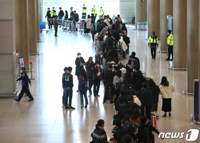 지난 23일 인천국제공항 1터미널에서 독일 프랑크푸르트발 여객기를 타고 입국한 승객들이 신종 코로나바이러스 감염증(코로나19) 진단 검사를 받기 위해 줄지어 서있다. /뉴스1 © News1