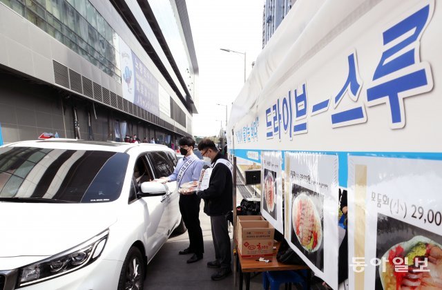 26일 서울 동작구 노량진수산시장에서 신종코로나바이러스 감염증(코로나19)으로 위축된 수산물 소비 활성화를 위해 마련된 수산물 드라이브 스루 판매소에 시민들이 수산물을 구입하고 있다.