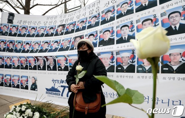 26일 오후 서울 광화문에서 열린 천안함 피격 10주기 순국용사 추모 기자회견에서 참가자들이 헌화를 위해 꽃을 들고 있다. 2020.3.26/뉴스1 © News1