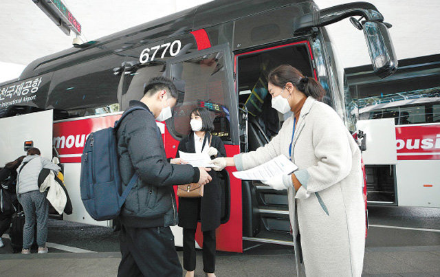 “입국자 귀가, 별도 교통편 이용을” 28일 인천국제공항에서 한국철도공사 직원들이 미국과 유럽에서 들어온 자가 격리 대상자의 귀가를 위해 별도로 마련한 공항철도(KTX) 광명역행 공항버스 탑승자들에게 안내문을 나눠주고 있다. 이들은 KTX 전용칸을 이용해 주요 역으로 이동한 뒤 자기 차량이나 지방자치단체가 마련한 교통수단으로 귀가했다. 인천=뉴스1