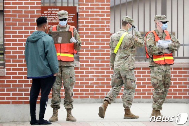 전 세계적인 신종 코로나바이러스 감염증(코로나19) 확산으로 주한미군 사령부가 공중 보건 비상사태를 선포한 가운데 26일 오후 경기도 평택 캠프 험프리스에서 미군 장병들이 마스크를 쓴 채 출입을 통제하고 있다. © News1