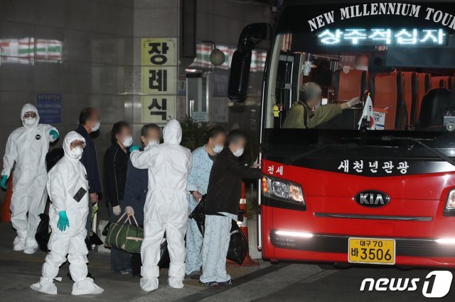 지난 30일 오후 신종 코로나바이러스 감염증(코로나19) 확진자가 무더기로 발생한 대구 달성군 다사읍 제2미주병원에서 방역당국이 확진자 일부를 상주적십자병원으로 이송하기 위해 버스에 태우고 있다. 대실요양병원과 제2미주병원 두 곳이 함께 사용하는 이 건물에서 200명이 넘는 확진자가 발생했다. 2020.3.30/뉴스1 © News1