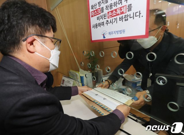 변덕승 특별자치법무담당관이 30일 오후 제주지방법원 민원실에 코로나19 증상에도 제주여행을 강행한 강남구 모녀를 상대로 한 손해배상 청구 소장을 제출하고 있다. 2020.3.30/뉴스1 © News1