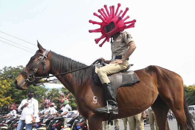 인도 첸나이의 한 경찰관이 코로나19 바이러스 모양의 헬멧을 쓰고 거리를 순찰하고 있다. AP=뉴시스