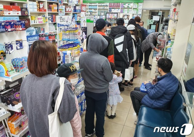 신종 코로나바이러스 감염증(코로나19)이 확산되고 있는 가운데 22일 서울시내 한 약국에 주중에 미처 마스크를 구입하지 못한 시민들이 마스크 구입을 위해 줄지어 서 있다.  © News1
