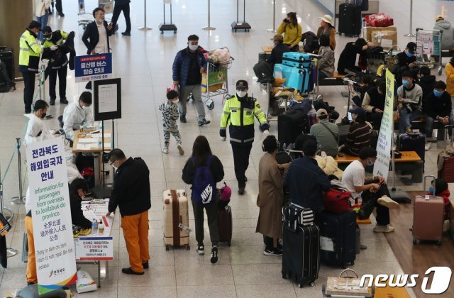 지난 1일 인천국제공항 제1여객터미널에서 신종 코로나바이러스 감염증(코로나19) 무증상 입국자들이 전용 공항버스를 타기 위해 대기하고 있다. 정부는 이날부터 해외발 입국자 전원에 대해 14일간 ‘자가격리’ 조치를 하기로 했다. © News1