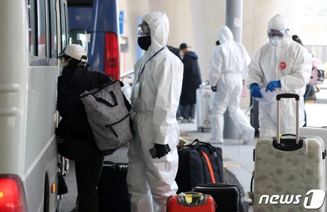 신종 코로나바이러스 감염증(코로나19) 환자가 전세계적으로 100만명을 돌파한 3일 오후 인천국제공항 1터미널에서 입국자들이 방호복을 입은 소방청 관계자들의 안내에 따라 버스를 타고 있다. 2020.4.3/뉴스1 © News1