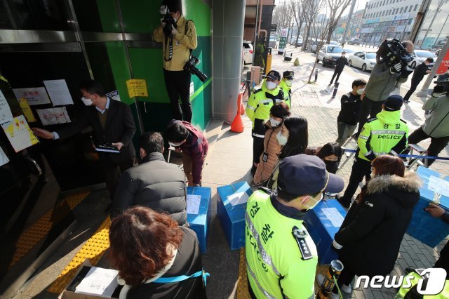 지난달 17일 오전 대구시 공무원들이 신천지 대구교회에 대한 행정조사를 통해 확보했던 컴퓨터 등 자료를 다시 들고 교회 건물로 들어가고 있다. 대구시와 경찰 등은 지난 12일 행정조사를 통해 컴퓨터 40여 대 등 신천지 내부 자료를 확보했지만, 보안프로그램으로 잠겨 있어 자료를 제대로 살펴보지 못한 것으로 알려졌다. © News1