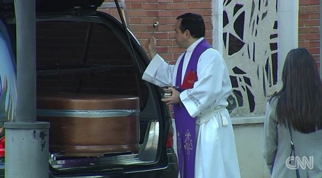 4일 스페인 마드리드에서 진행된 드라이브스루 장례식서 사제가 성수를 뿌리는 모습. CNN 화면 캡처