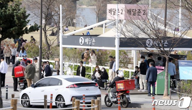 6일 오후 서울 영등포구 여의나루역 여의도 공원 배달존에 수많은 시민들이 배달음식을 기다리고 있다. 2020.4.6/뉴스1 © News1