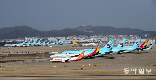 항공기 운항률이 90% 이상 감소한 가운데 인천국제공항 활주로 옆에 대한항공, 아시아나 여객기가 주기되어있다.