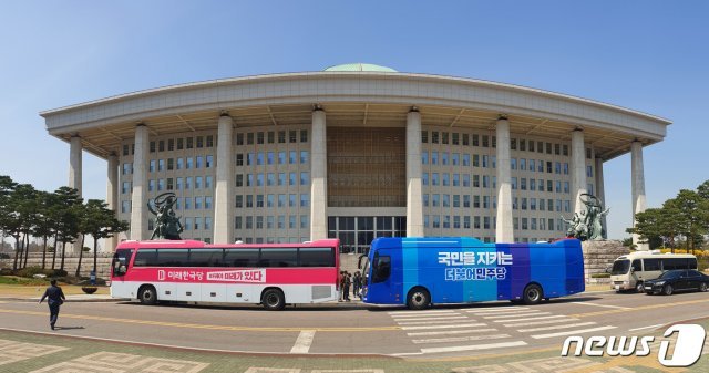 서울 여의도 국회 본청 앞에 더불어민주당과 미래통합당 유세버스가 나란히 서있다. © News1