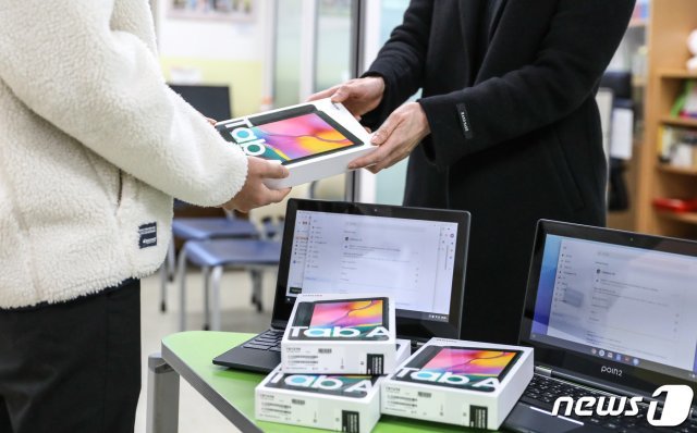 지난 8일 서울의 한 중학교에서 학생이 태블릿PC를 지급받고 있다. /뉴스1 © News1