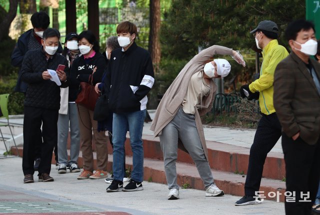 아침 체조
15일 오전 투표소가 마련된 서울 영등포구 여의도중학교에서 유권자들이 소중한 한 표를 행사하기 위해 길게 줄을 서 있다. 한 시민이 체조를 하고 있다. 송은석 기자 silverstone@donga.com