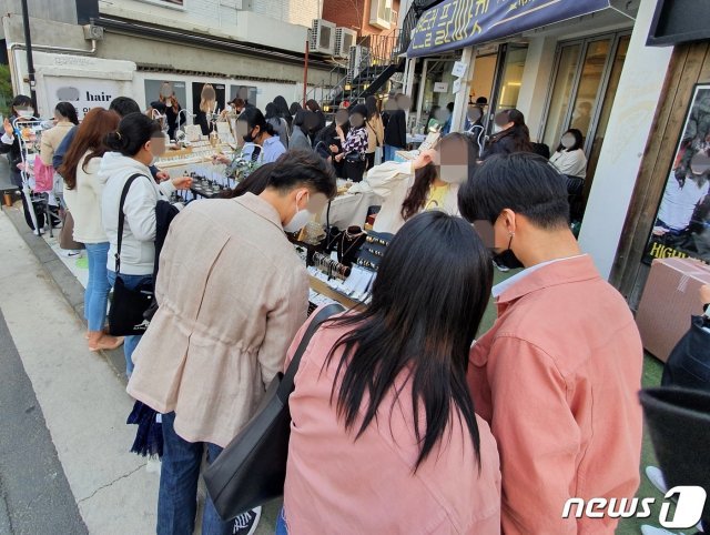 제21대 국회의원선거 투표 당일인 15일, 신종 코로나바이러스 감염증(코로나19) 확산 방지를 위해 투표소 내에는 ‘사회적 거리두기’ 1m 간격 유지에 무증상 자가격리자 투표시간 조정 등 갖은 노력을 했으나 서울 마포구 홍대입구역 인근을 찾은 젊은 층이 플리마켓을 구경하고 있다. © News1