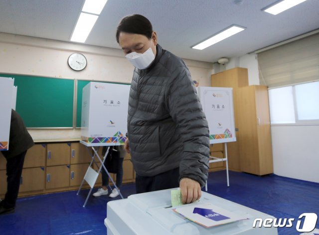 윤석열 검찰총장이 제21대 국회의원선거일인 15일 오전 서울 서초구 원명초등학교에 마련된 투표소에서 투표를 하고 있다. 2개월 여 만에 언론 카메라에 포착된 윤 총장은 이날 홀로 투표소를 찾아 마스크를 쓴 채 한 표를 행사했다. 2020.4.15/뉴스1 © News1