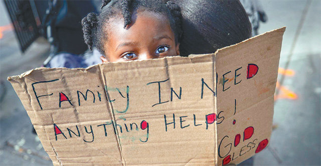 뉴올리언스 길 한 모퉁이에서 ‘도움이 필요한 가족, 무엇이든 도움이 됩니다‘는 문구가 쓰인 박스 종이를 들고 있는 여자아이. AP통신에 따르면 이 아이의 어머니는 최근 코로나19로 실직했다. 뉴올리언스=AP 뉴시스