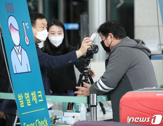 8일 오후 인천국제공항 출국장에서 한 탑승객이 체온을 재고 있다. © News1