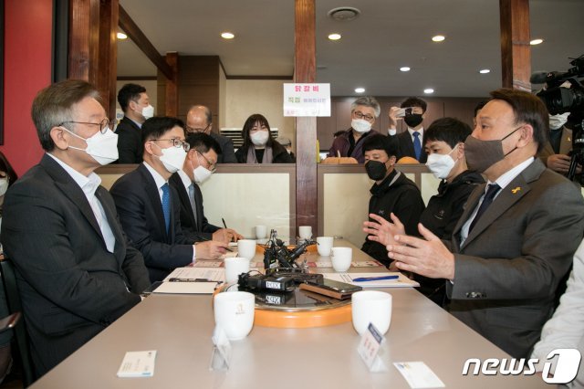 이재명 경기도지사(왼쪽)가 17일 공공 배달앱 ‘배달의명수’를 운용하고 있는 전북 군산을 찾아 실질적인 배달앱 효과와 운영사항을 집중 점검하고 있다. 이 지사는 이날 오전 군산시 수송동 소재 원할머니보쌈 군산수송점을 찾아 함께 참석한BHC치킨 업주 등 가맹점주들과 직접 대담을 가졌다.2020.4.17 /뉴스1 © News1