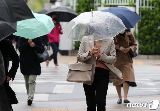 17일 오전 서울 세종로에서 마스크와 우산을 쓴 시민들이 출근길 발걸음을 재촉하고 있다. 2020.4.17/뉴스1 © News1