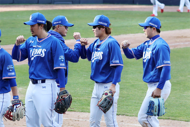 코로나가 바꾼 야구장 풍경 21일 올해 들어 처음으로 프로야구 팀 간 연습경기가 시작됐다. 신종 코로나바이러스 감염증(코로나19)은 야구장 풍경도 바꿔 놓았다. 삼성 선수들이 광주에서 열린 KIA전에서 4-2로 승리한 뒤 손바닥 대신 팔뚝을 부딪치면서 기쁨을 나누고 있다. 광주=뉴스1·AP 뉴시스