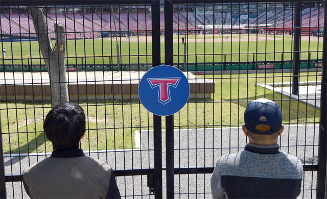 ‘무관중’ 정책으로 경기장에 들어가지 못한 팬들이 광주 KIA챔피언스필드 철조망 밖에서 경기를 지켜보고 있다. 광주=뉴스1·AP 뉴시스