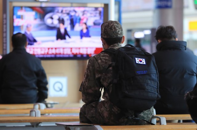 23일 서울역 대합실에서 한 장병이 코로나19 관련 뉴스를 시청하고 있다. 사진=뉴스1