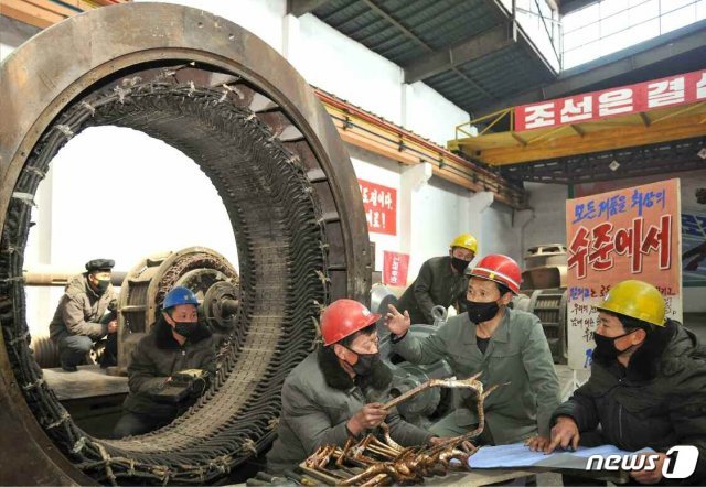 (평양 노동신문=뉴스1) = 성천강전기공장. 안전모와 마스크를 착용한 노동자들 뒤로는 정면 돌파전을 추동하기 위한 차원에서 ‘모든 제품을 최상의 수준에서’라는 선전 문구가 적혀있다. [국내에서만 사용가능. 재배포 금지. DB 금지. For Use Only in the Republic of Korea. Redistribution Prohibited] rodongphoto@news1.kr