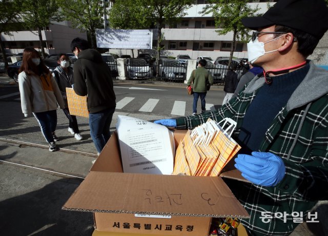 4일 오전 서울 영등포구 여의도여자고등학교 정문에서 교사들이 ‘워크스루’ 방식으로 문제지를 전달하고 있다.