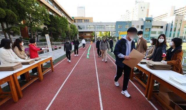 24일 오전 서울 영등포구 여의도고에서 고3 학생들이 워킹 스루 방식으로 시험지를 배부 받고 있다. 뉴시스