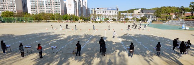 24일 오전 대구 수성구 황금동 경북고등학교 운동장에서 교사들이 워킹 스루 방법으로 학생간 대면을 최소화 하며 전국연합학력평가 시험지를 학생들에게 배부하고 있다. 대구=뉴시스