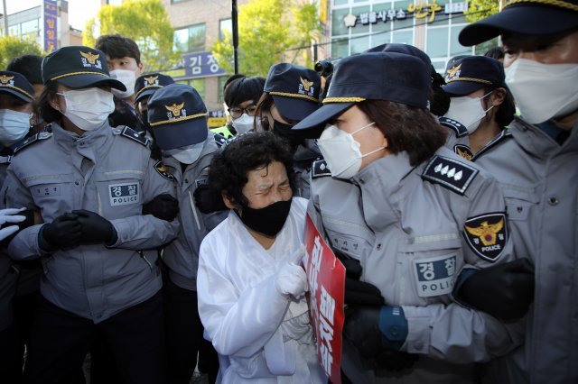 전두환 씨의 광주 재판이 진행되고 있는 27일 오후 광주 동구 광주지방법원 후문에서 한 오월어머니가 경찰들에게 둘러싸여 이동을 저지당하고 있다. 사진=뉴스1