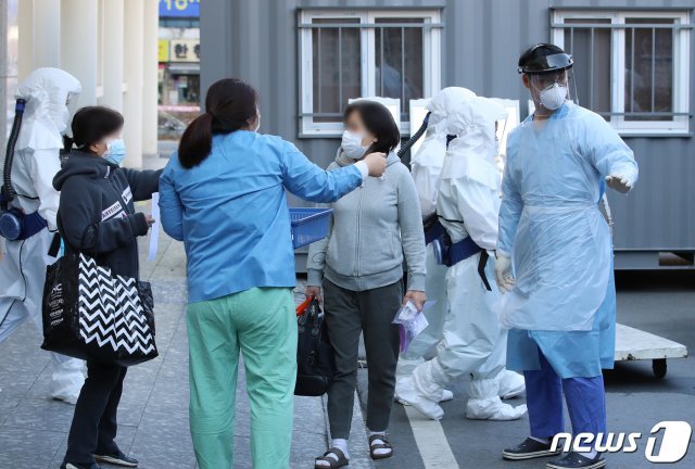 미국 샌디에이고의대 연구팀이 27일(현지시간) 후각상실을 경험한 신종 코로나바이러스 감염증(코로나19) 환자들은 입원이 필요없는 경미한 증상에 그칠 가능성이 많다는 연구결과를 발표했다. 사진은 지난달  16일코로나19 확진으로 입원 치료를 받던 여성이 퇴원을 앞두고 의료진의 주의사항을 듣고 있다.  2020.3.16/뉴스1 © News1