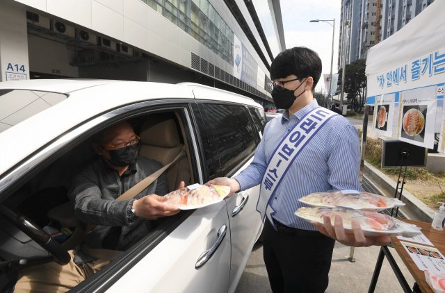 수협중앙회 관계자들이 26일 서울 영등포구 노량진수산시장에서 신종 코로나바이러스 감염증 사태로 위축된 수산물 소비 활성화를 위해 차에 탄 채 물건을 구입할 수 있는 ‘드라이브 스루’ 판매 방식으로 수산물을 판매하고 있다. 사진공동취재단