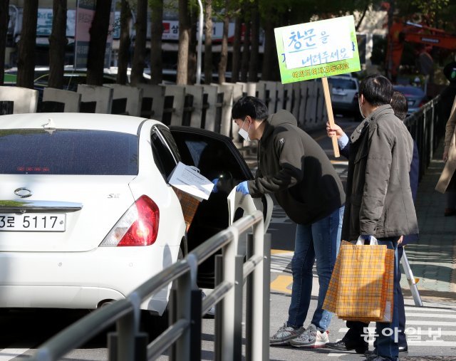 2020학년도 첫 전국연합학력평가가 시행된 24일 오전 서울 영등포구 여의도여자고등학교 정문에서 교사들이 ‘드라이브 스루’ 방식으로 문제지를 전달하고 있다. 최혁중 기자 sajinman@donga.com