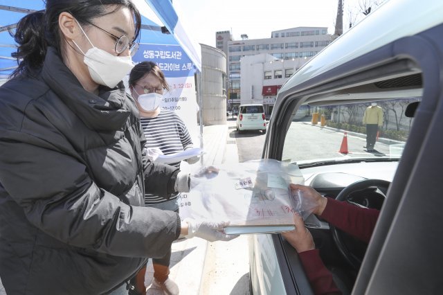 11일 서울 성동구 행당동 구립도서관 앞에서 차량을 탄 주민이 비닐로 포장된 책을 대출하고 있다. 성동구 제공