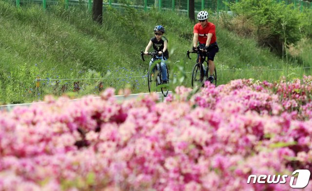 서울의 최고기온이 28도까지 오르는 등 초여름 날씨를 보인 3일 서울 양화한강공원에서 반팔차림의 시민들이 자전거를 타고 있다. 2020.5.3/뉴스1 © News1